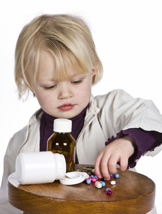 Little girl playing a dangerous game with medical pills