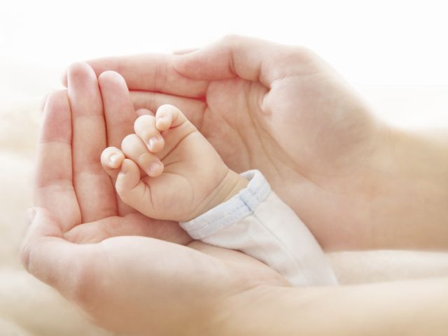 Newborn baby hand in mother hands. Help asistance concept
