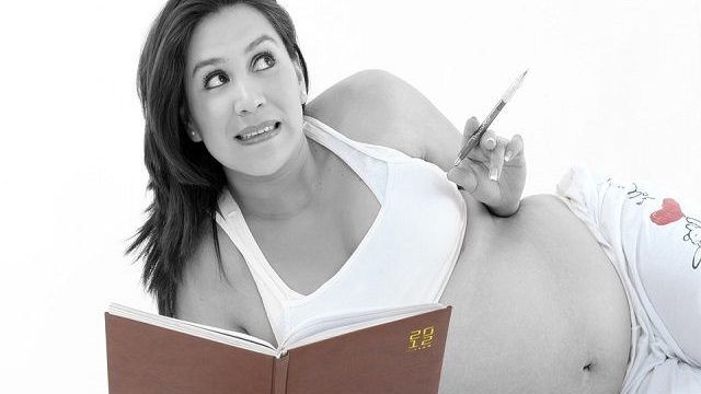 donna in gravidanza che prende appunti