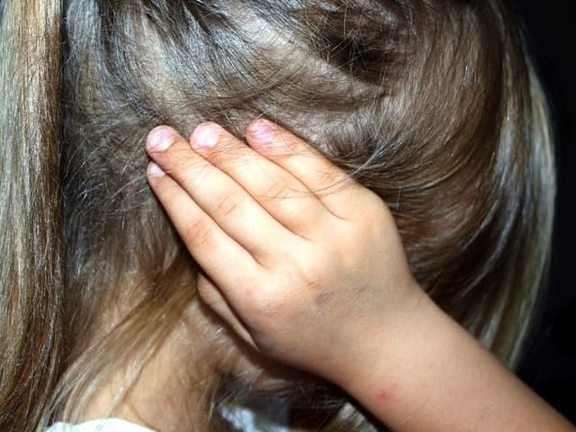 foto bambina con le mani alle orecchie